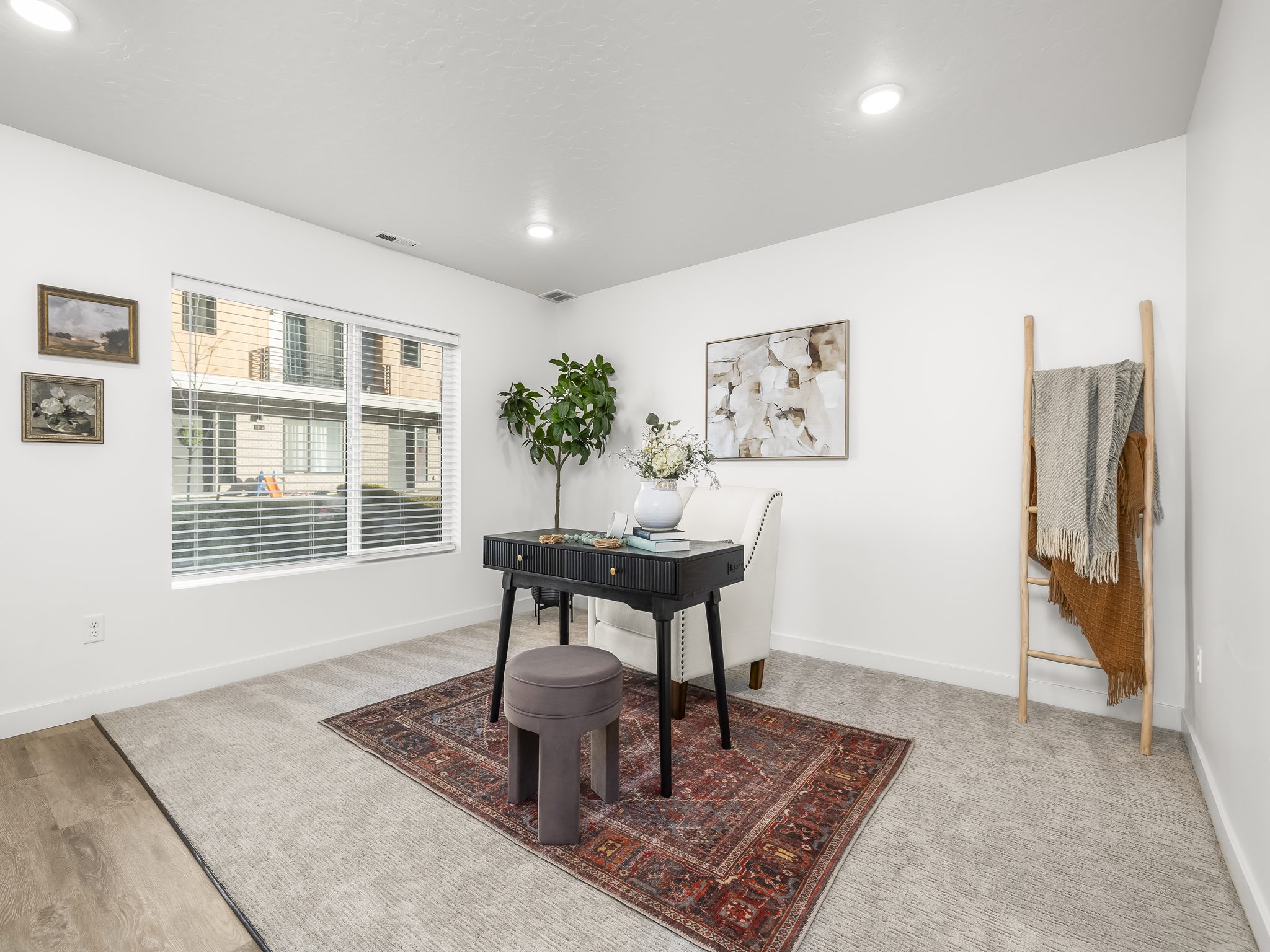 Interior room featuring a large window with horizontal blinds, recessed lighting, and a combination of carpet and wood-finish flooring