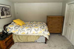 Bedroom featuring light gray walls, gray carpeting, and white bi-fold closet doors