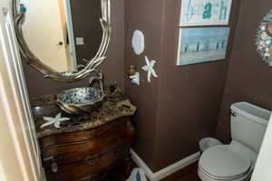 Vanity featuring a mosaic vessel sink, marble-finish countertop, and decorative mirror