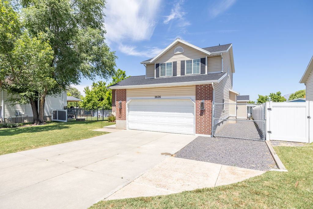 Two-story property featuring a front-facing garage with a concrete driveway