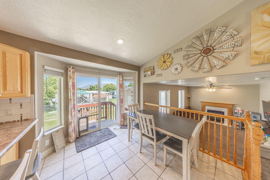 Bright dining area featuring tile flooring, a bay window, and sliding glass door access to an exterior deck