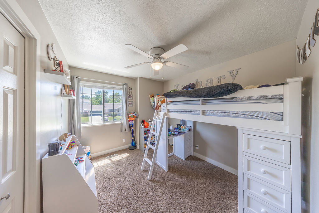 Carpeted room with a ceiling fan, a window, and light-toned walls