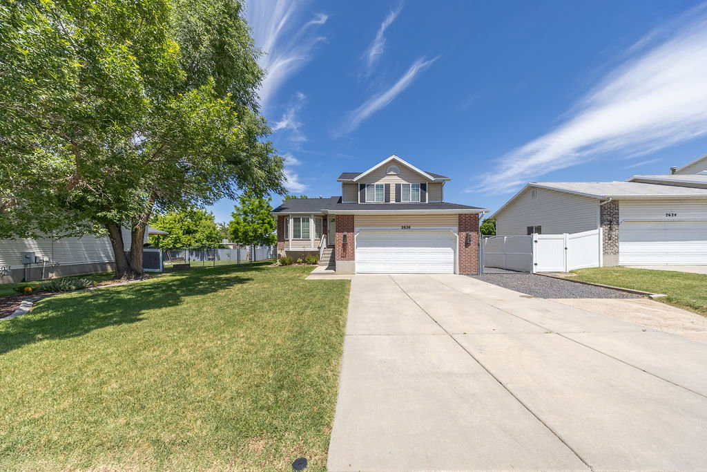 Two-story residence featuring a brick and siding exterior, an attached two-car garage, and a concrete driveway