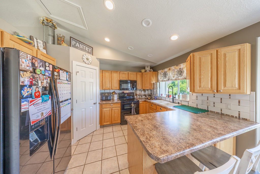 Kitchen featuring wood-finish cabinetry, a patterned countertop, and tile flooring