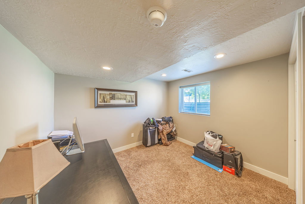 Carpeted room with recessed lighting and a window featuring horizontal blinds
