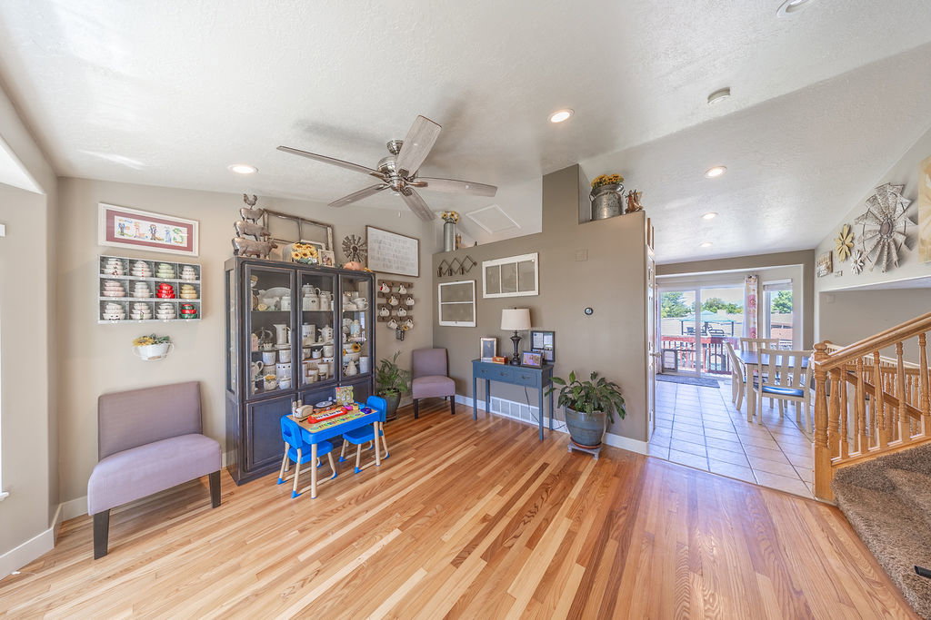 Spacious open-concept living area featuring wood-finish flooring, recessed lighting, and a ceiling fan