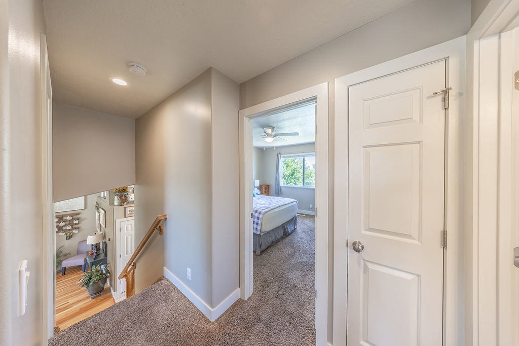 Second-story landing with neutral carpet flooring and light-toned walls