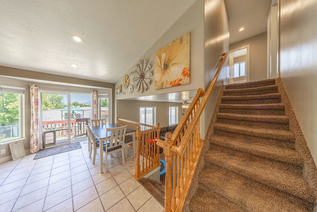 Carpeted staircase with wood banister and railing