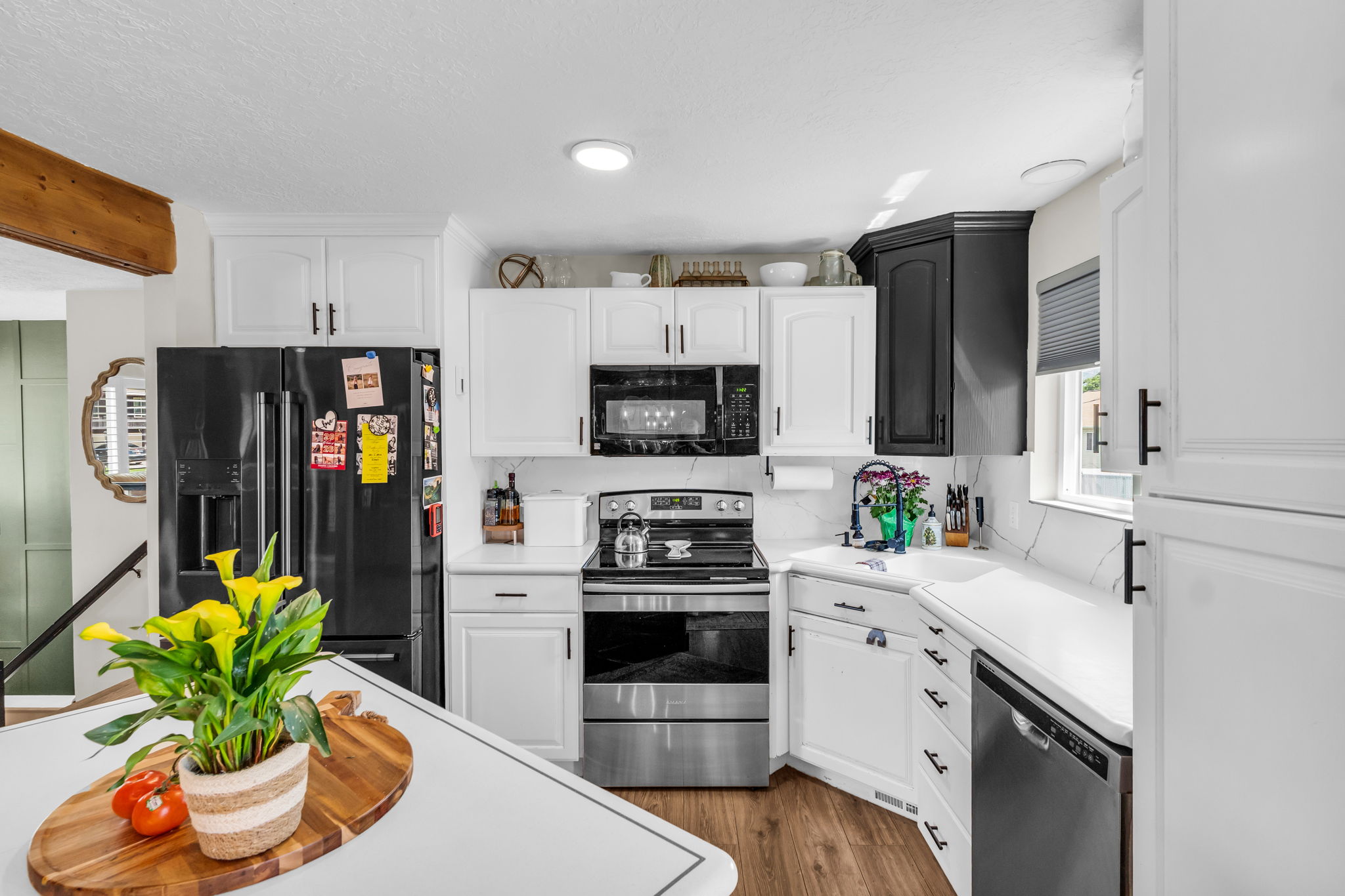 Kitchen featuring two-tone cabinetry, stainless steel appliances, wood-finish flooring, recessed lighting, and a white countertop with a matching backsplash