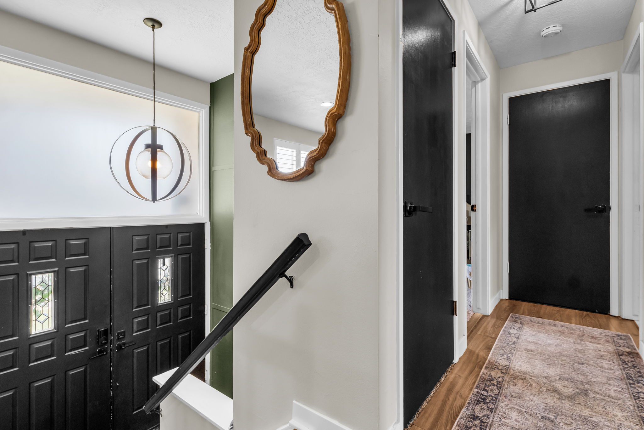 Foyer entry with dark paneled double doors and frosted transom windows