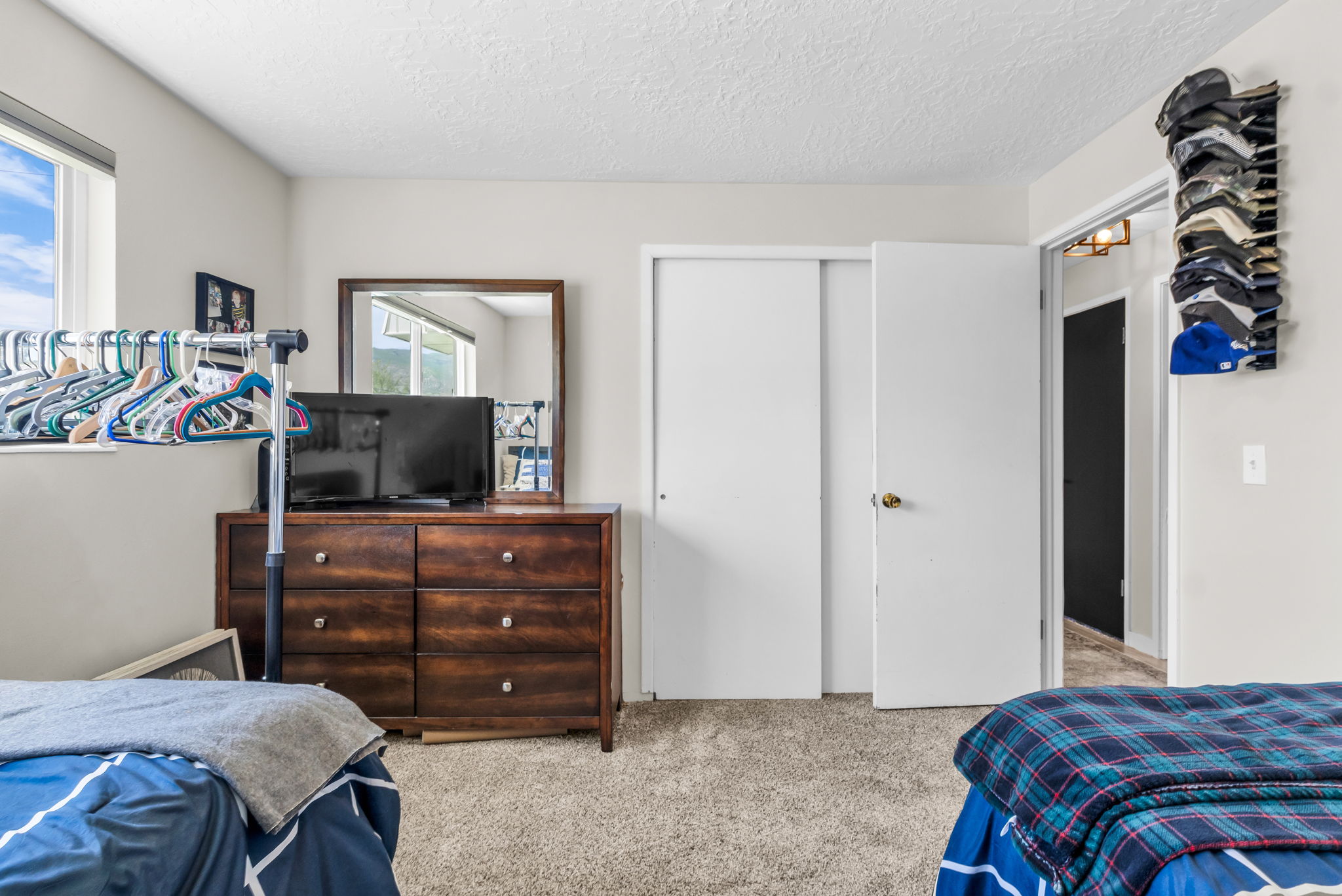 Carpeted room featuring light neutral wall paint and a textured ceiling