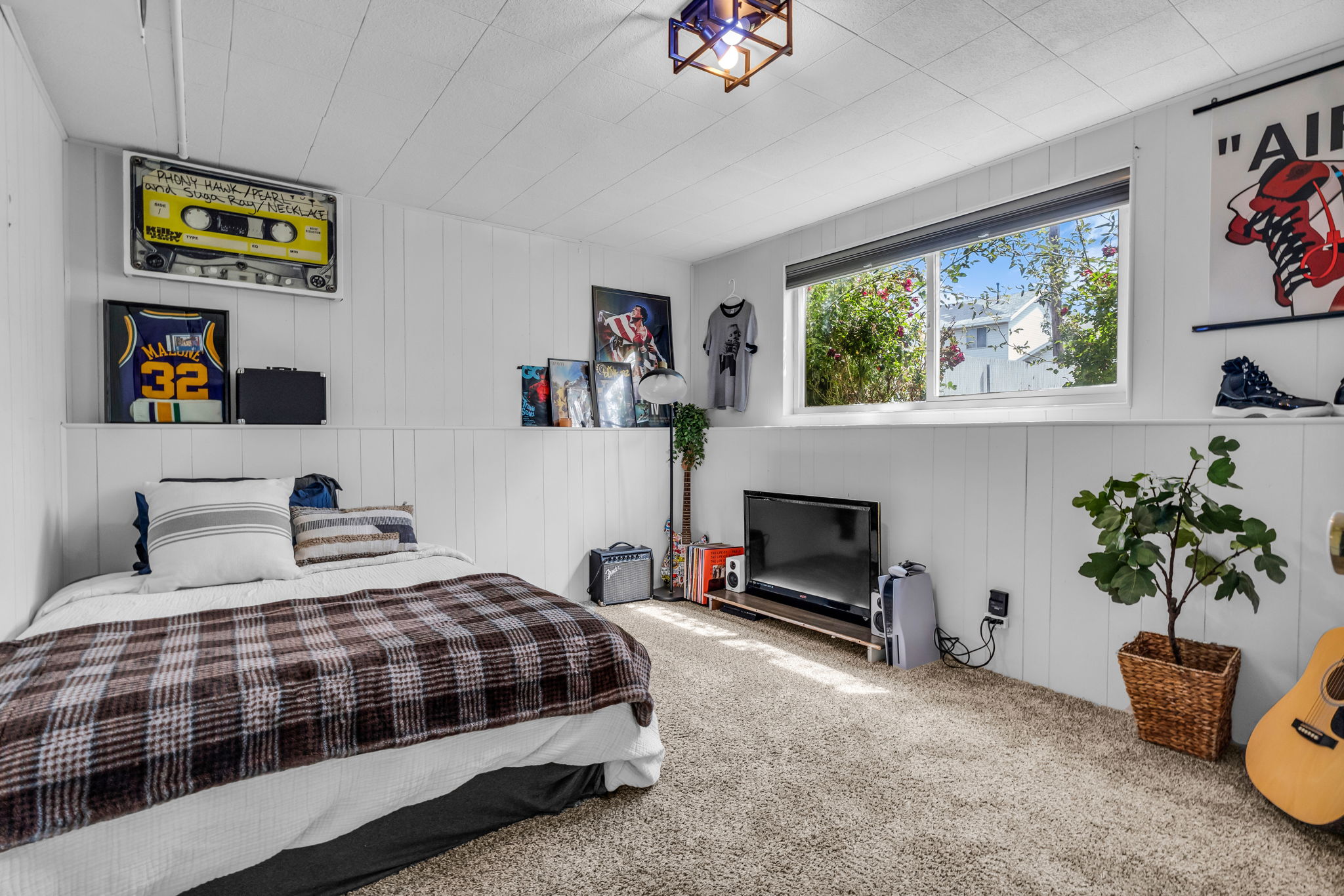 Carpeted room featuring white vertical paneling and a horizontal accent shelf