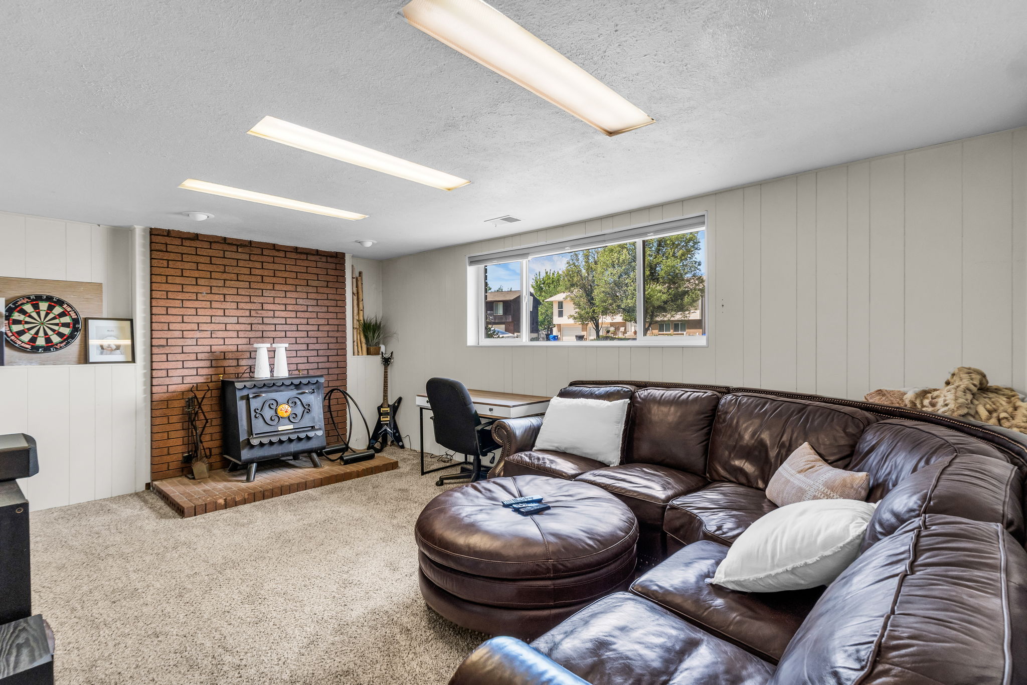 Inviting living area featuring a prominent brick-clad wall with a classic wood-burning stove