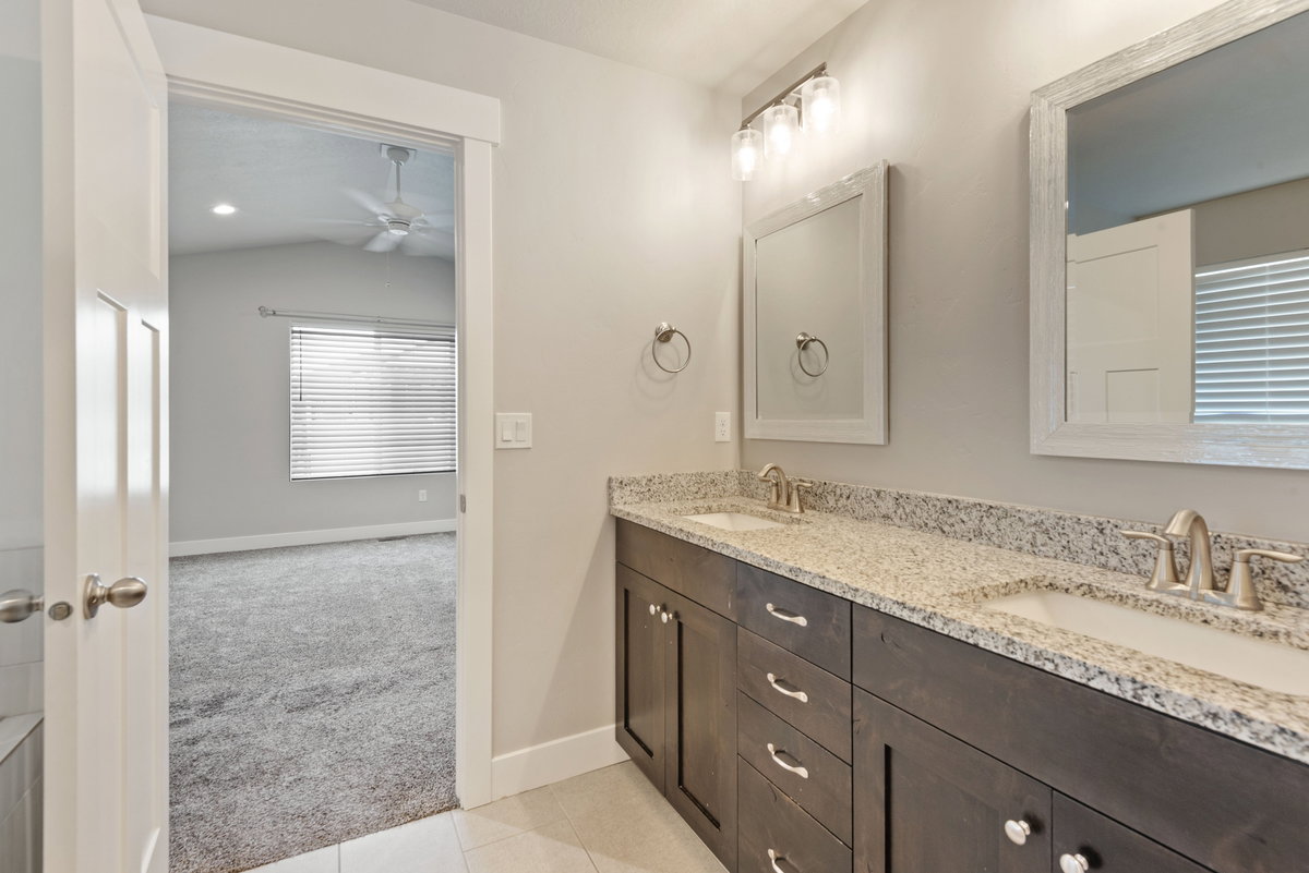 Double vanity with granite countertops, undermount sinks, and brushed nickel fixtures