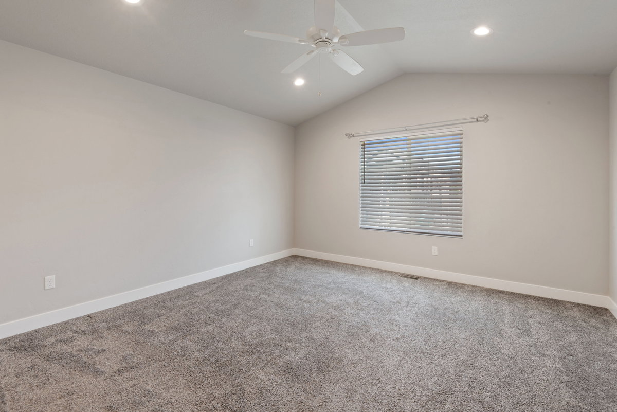 Spacious room featuring vaulted ceilings, recessed lighting, and a ceiling fan