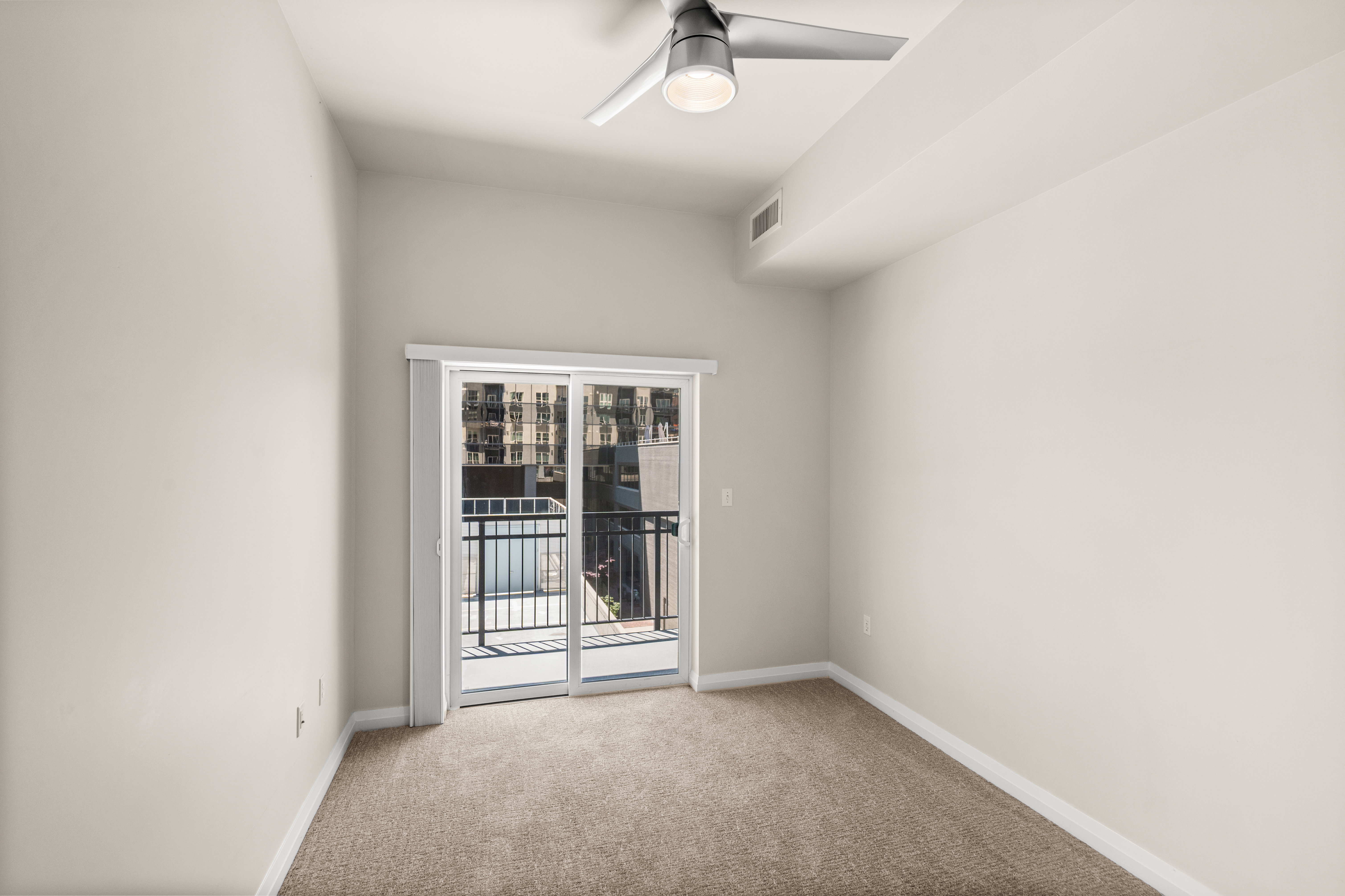 Room featuring neutral-toned carpeting, light-painted walls, and a contemporary ceiling fan with integrated lighting