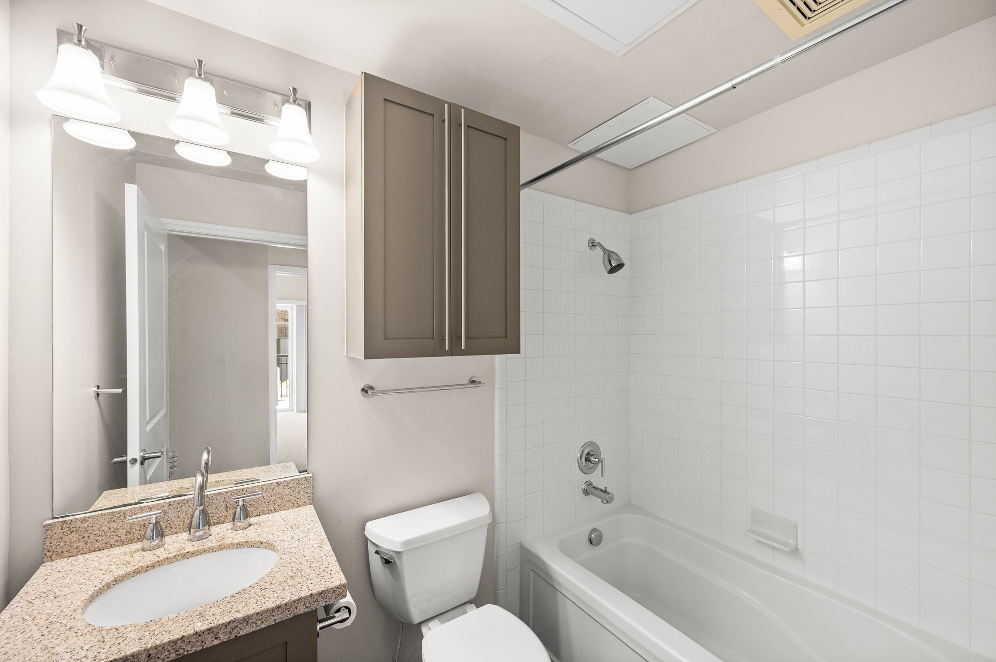 Bathroom featuring a vanity with a stone-finish countertop, undermount sink, and chrome faucet