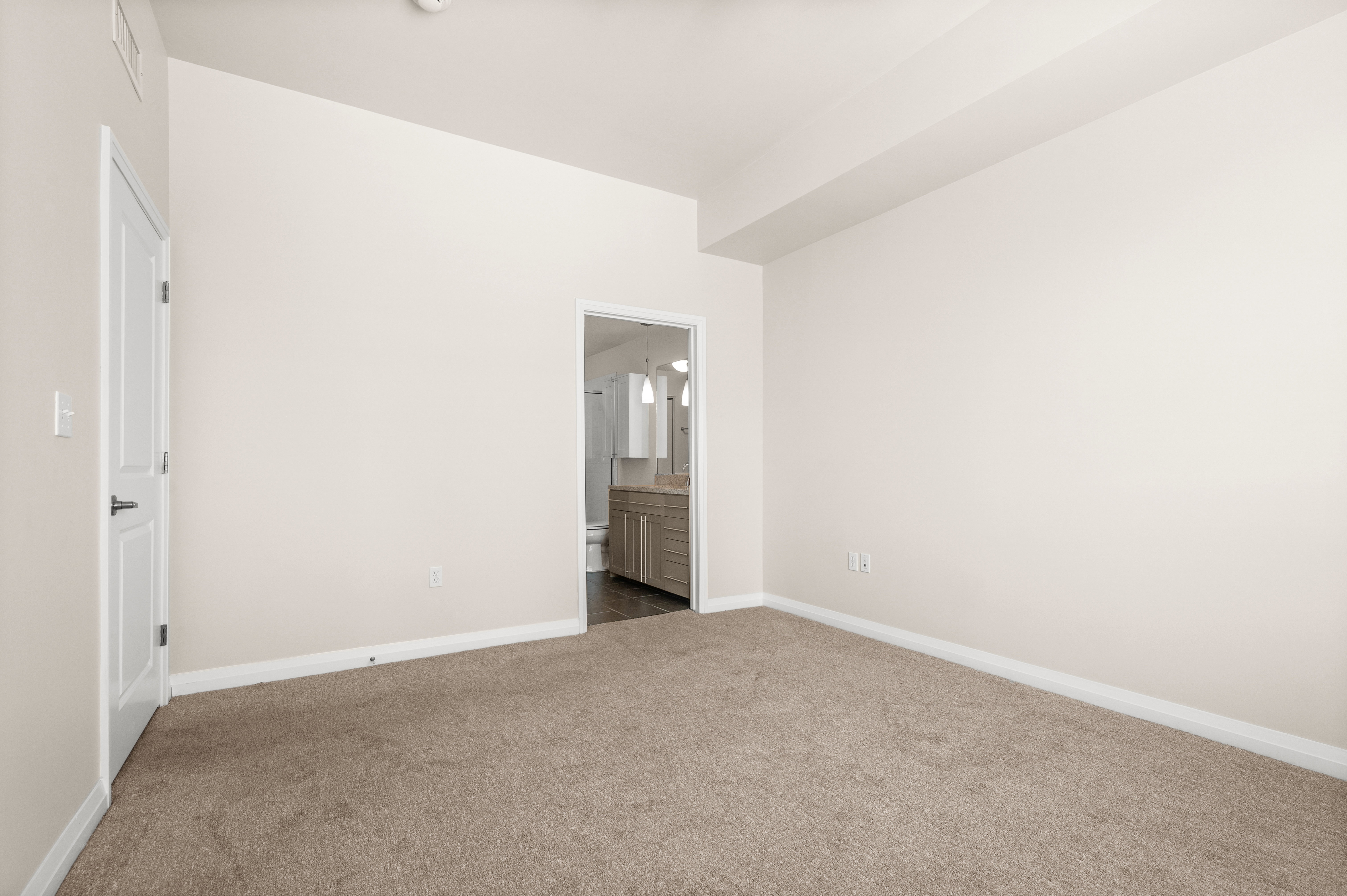 Bedroom featuring neutral carpeting, light-toned walls, and white trim