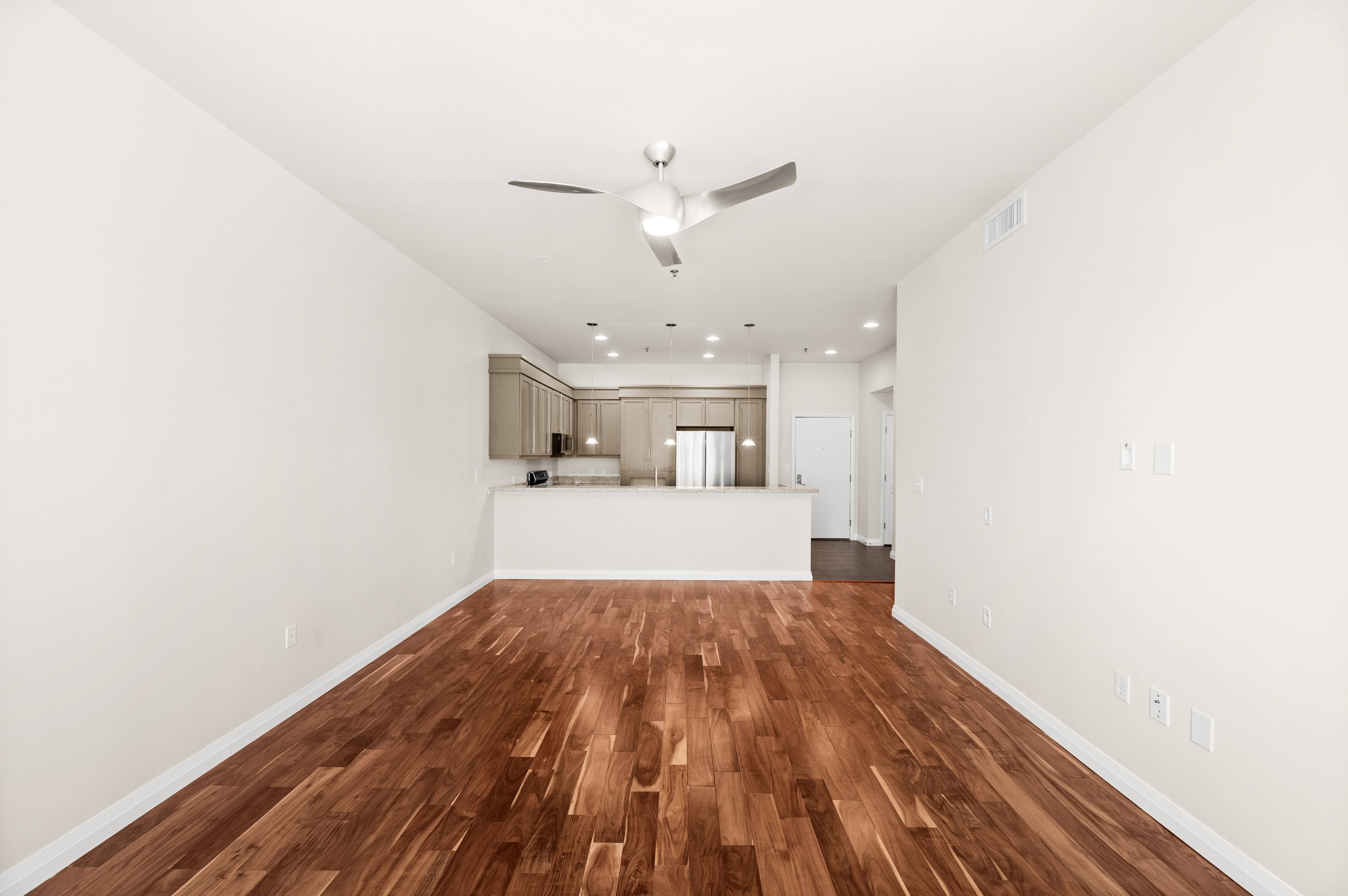 Open-concept living space featuring wood-finish flooring, a modern ceiling fan, and recessed lighting