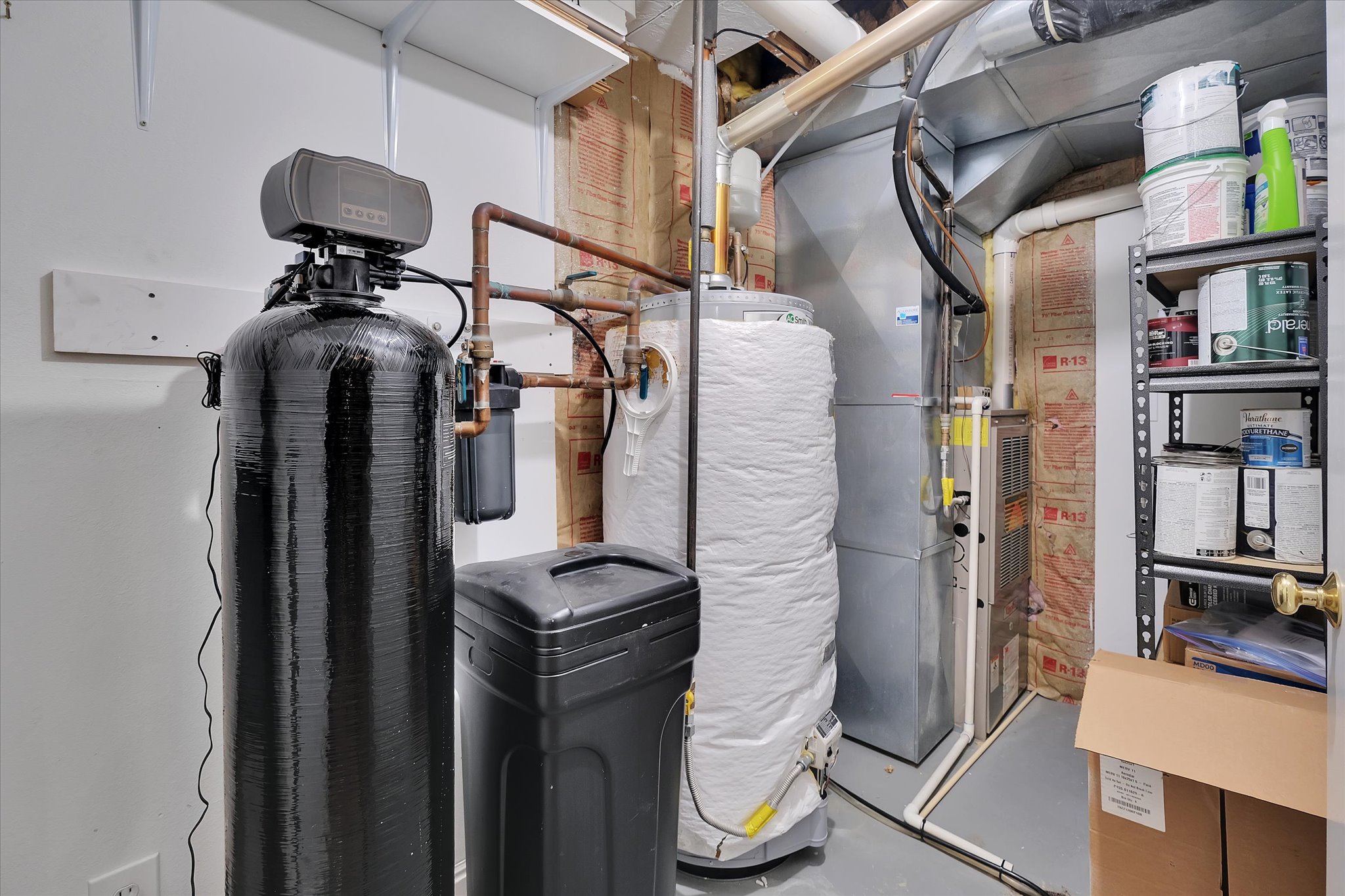 Utility area featuring a water softener system, water heater, and furnace