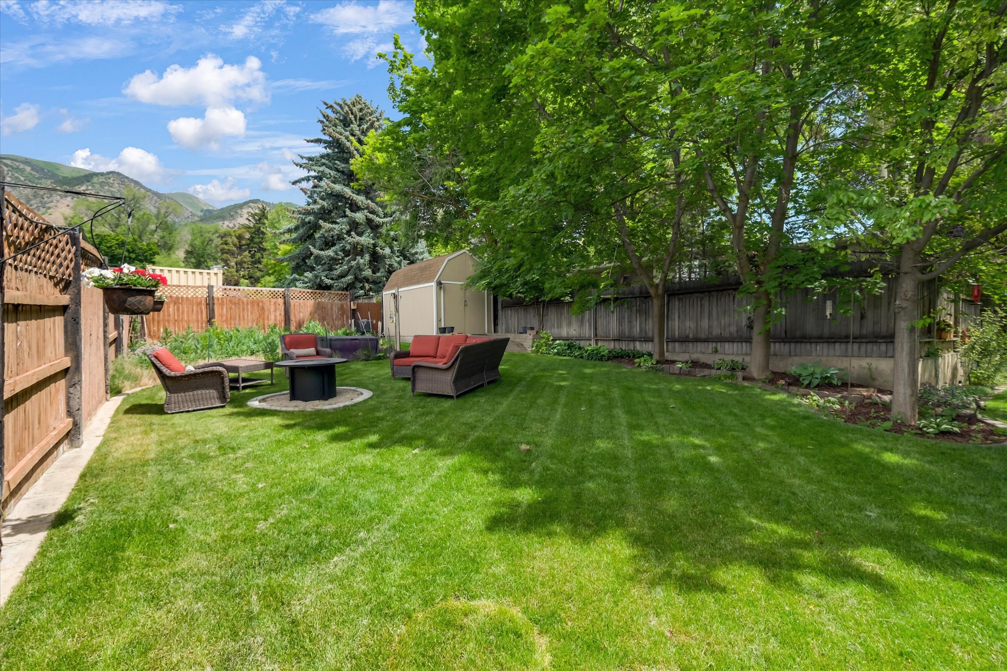 Expansive green lawn with mature trees and perimeter fencing