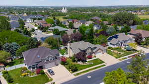 Residential street lined with homes featuring varied architectural styles, mature landscaping, and established driveways
