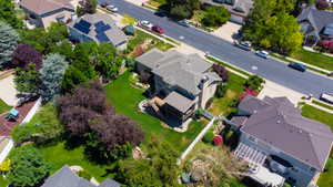 Spacious property featuring a multi-level deck, expansive green lawn, mature landscaping, and a fenced perimeter