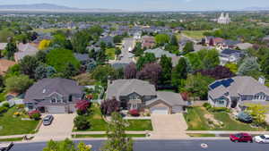 Residential street with mature landscaping, diverse rooflines, and distant mountain scenery