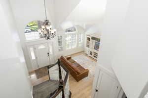 Two-story entryway featuring a decorative chandelier and an arched window