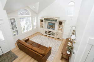 Two-story great room featuring high vaulted ceilings and light wood-finish flooring