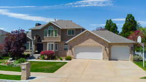 Stately residence featuring a brick and stucco exterior, arched window details, and a multi-car driveway