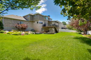 Expansive green lawn with a multi-level deck and covered patio