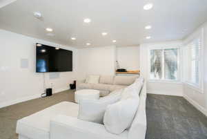 Spacious living area featuring recessed lighting, integrated ceiling speakers, and a large wall-mounted display
