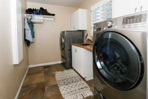 Laundry room featuring large format tile flooring, white shaker-style cabinetry, granite-look countertops, and a stainless steel sink with a gooseneck faucet