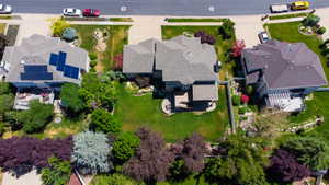 Spacious property featuring a large green lawn, mature landscaping, and an expansive paved patio