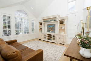 Vaulted ceilings featuring recessed lighting and an arched transom window