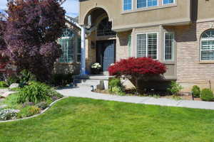 Brick and stucco exterior featuring an arched entryway and a bay window