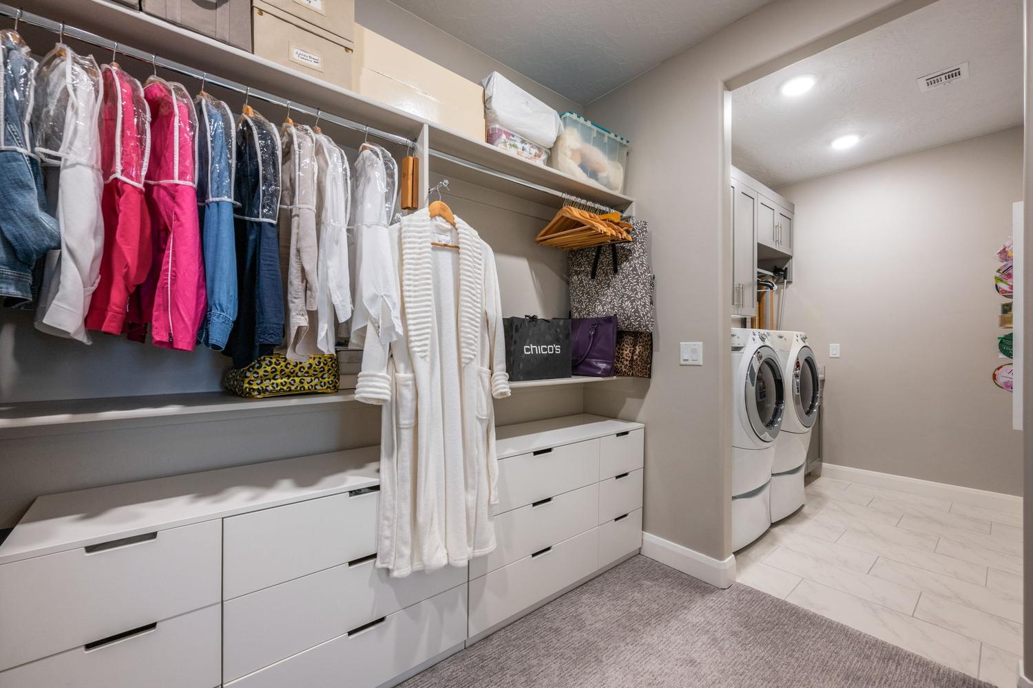 Custom closet system featuring multiple hanging rods and extensive built-in drawer storage