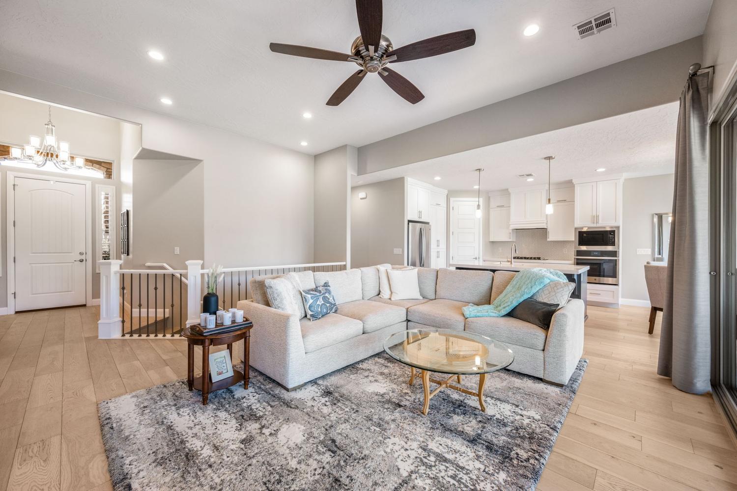 Open-concept living area featuring light wood-finish flooring, recessed lighting, and a ceiling fan