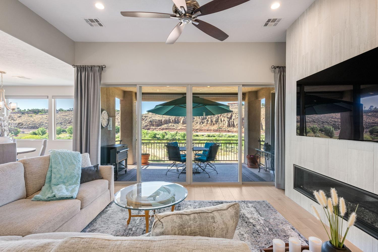 Open-concept living area featuring light wood-finish flooring and a built-in linear fireplace with a textured accent wall