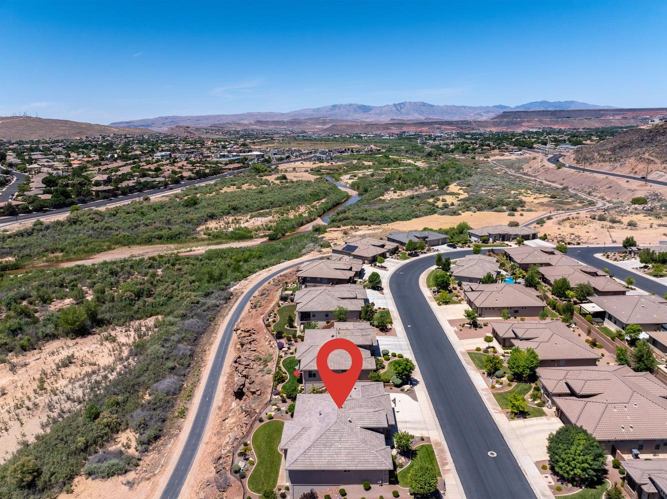 Aerial overview showcasing a residential community with single-story homes and landscaped yards