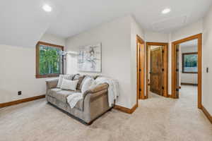 Carpeted interior area featuring natural wood trim, recessed lighting, and multiple paneled wood doors