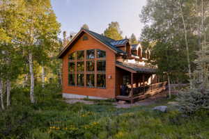 Wood-sided home with a green metal roof and a prominent wall of windows