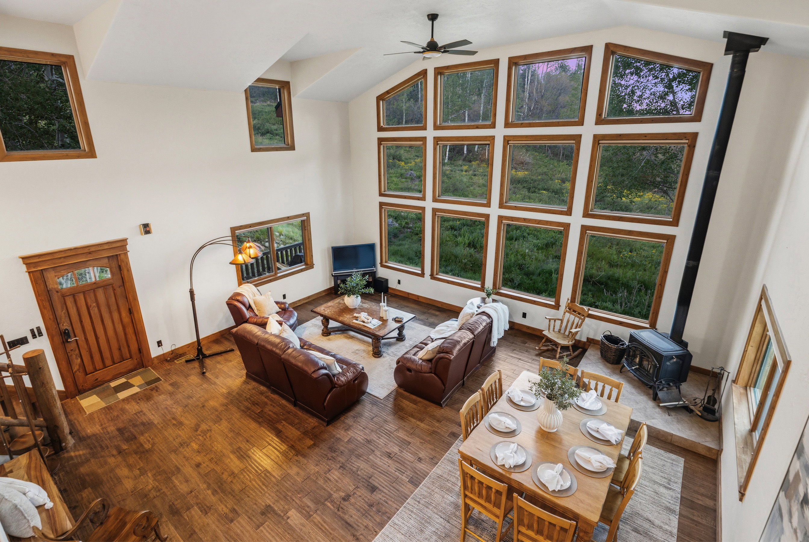 Vaulted great room featuring wood-finish flooring and a wood-burning stove