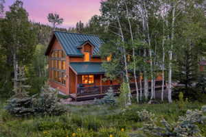 Wood-sided structure with a dark green metal roof