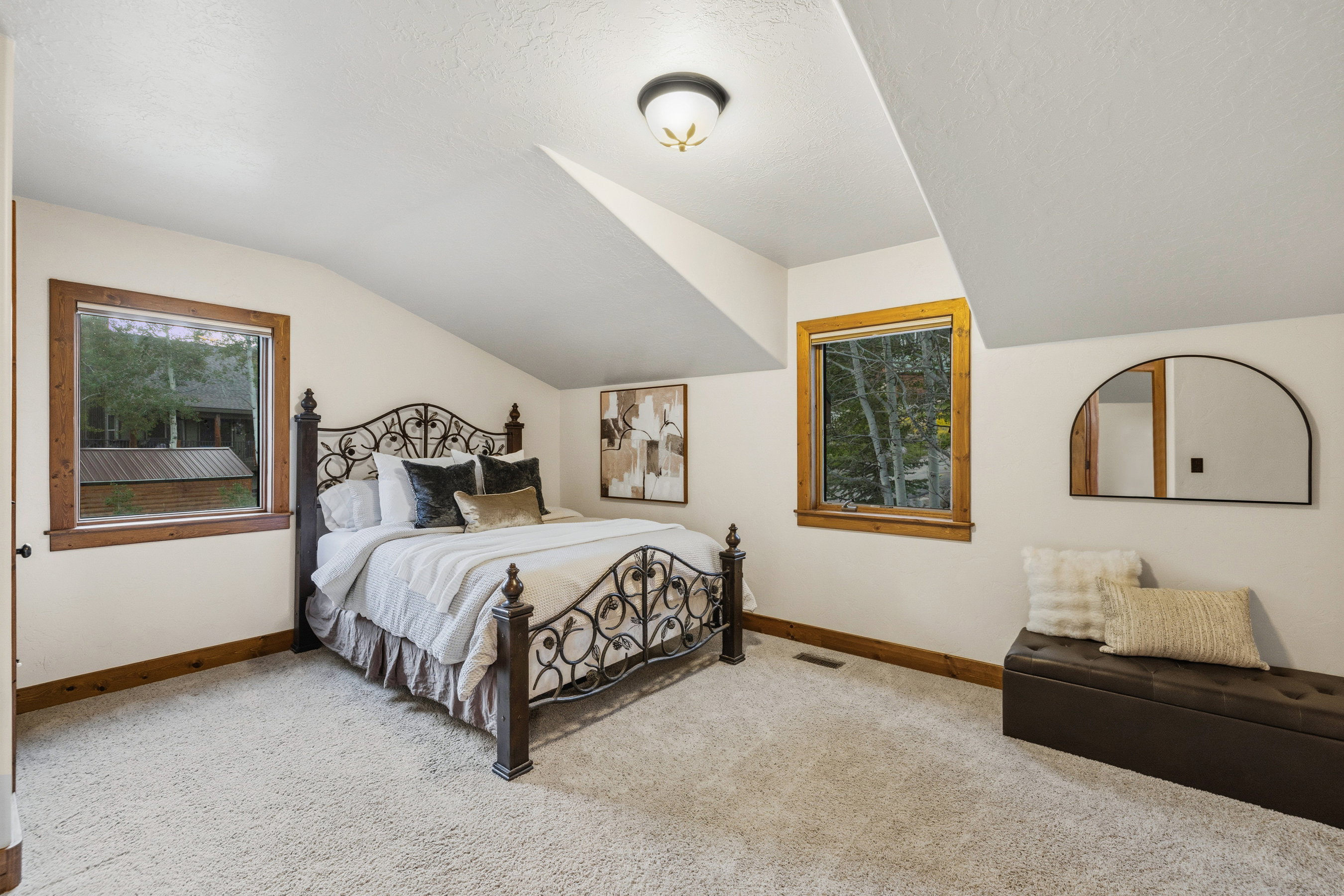Carpeted room featuring a sloped ceiling and two windows with wood trim