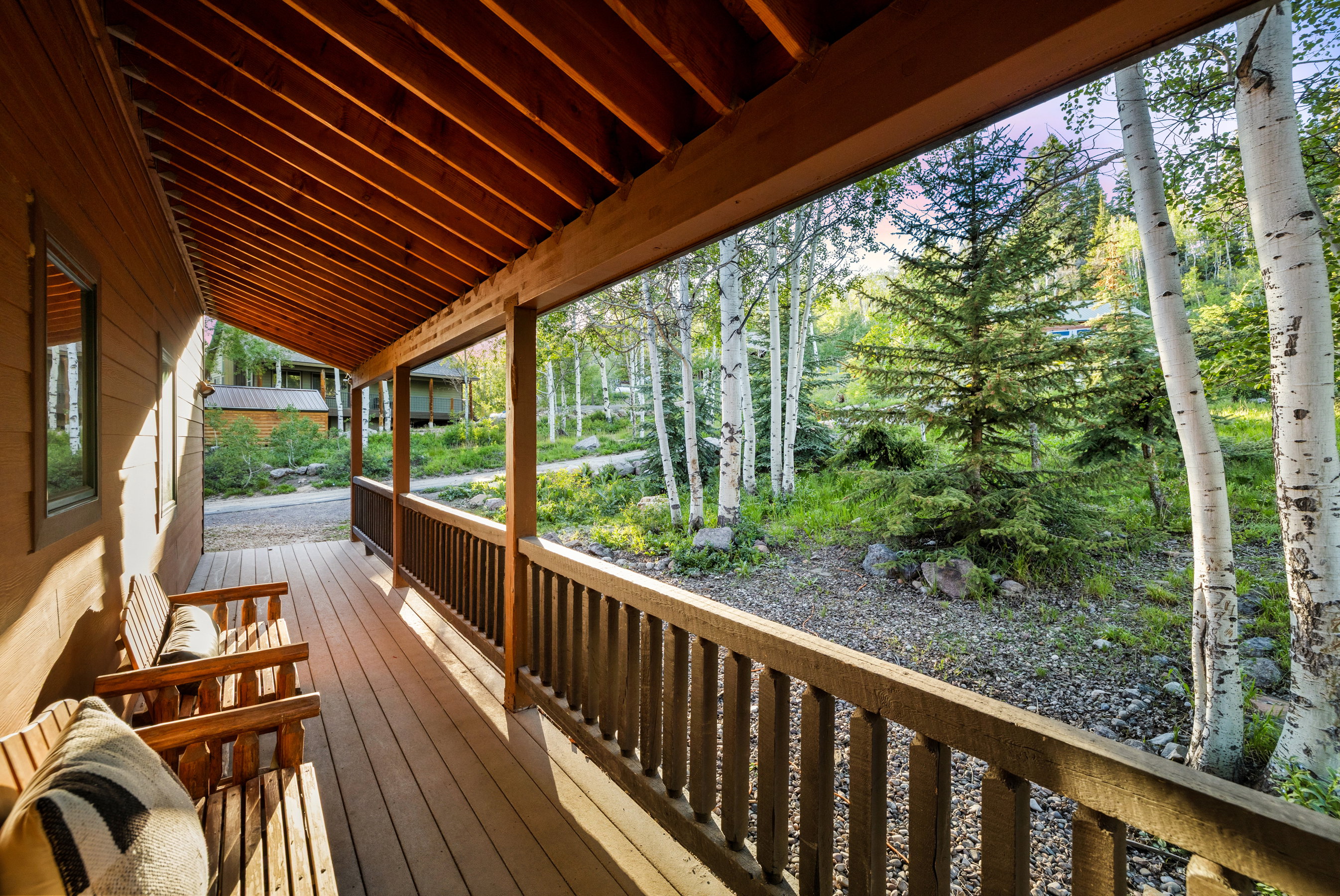 Wood-finish covered porch featuring a slatted wood ceiling, wood-plank flooring, and wood railing
