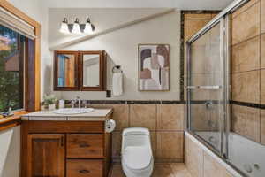 Bathroom featuring a wood-finish vanity with an undermount sink and a light-toned countertop