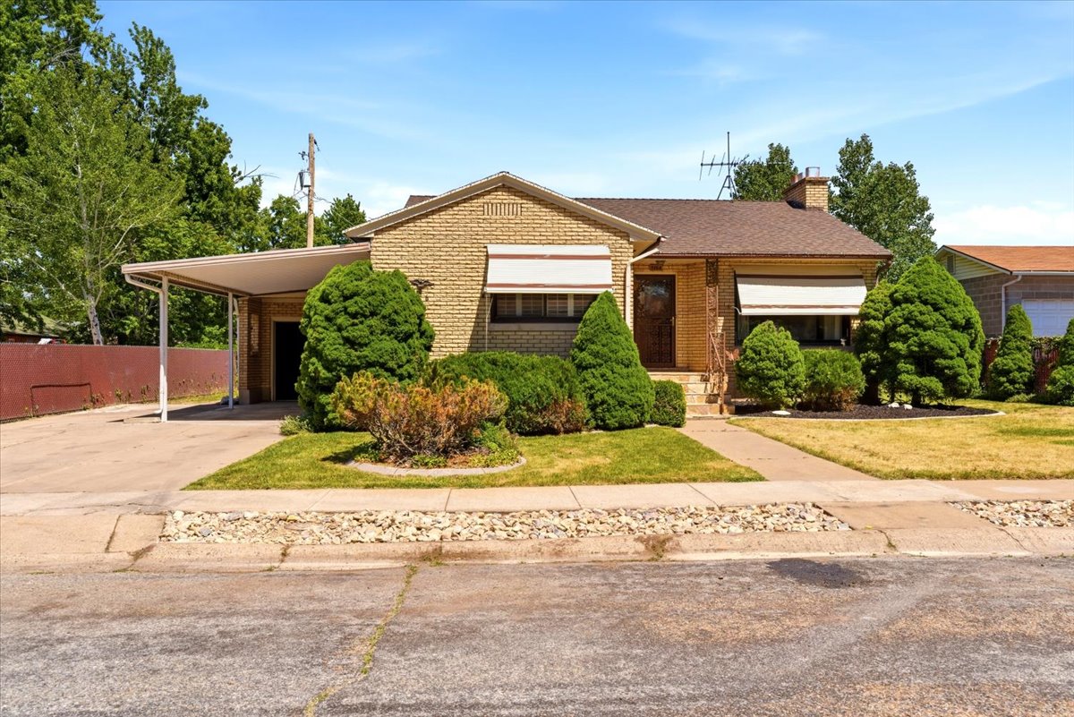 Brick exterior with a peaked roof and an attached carport
