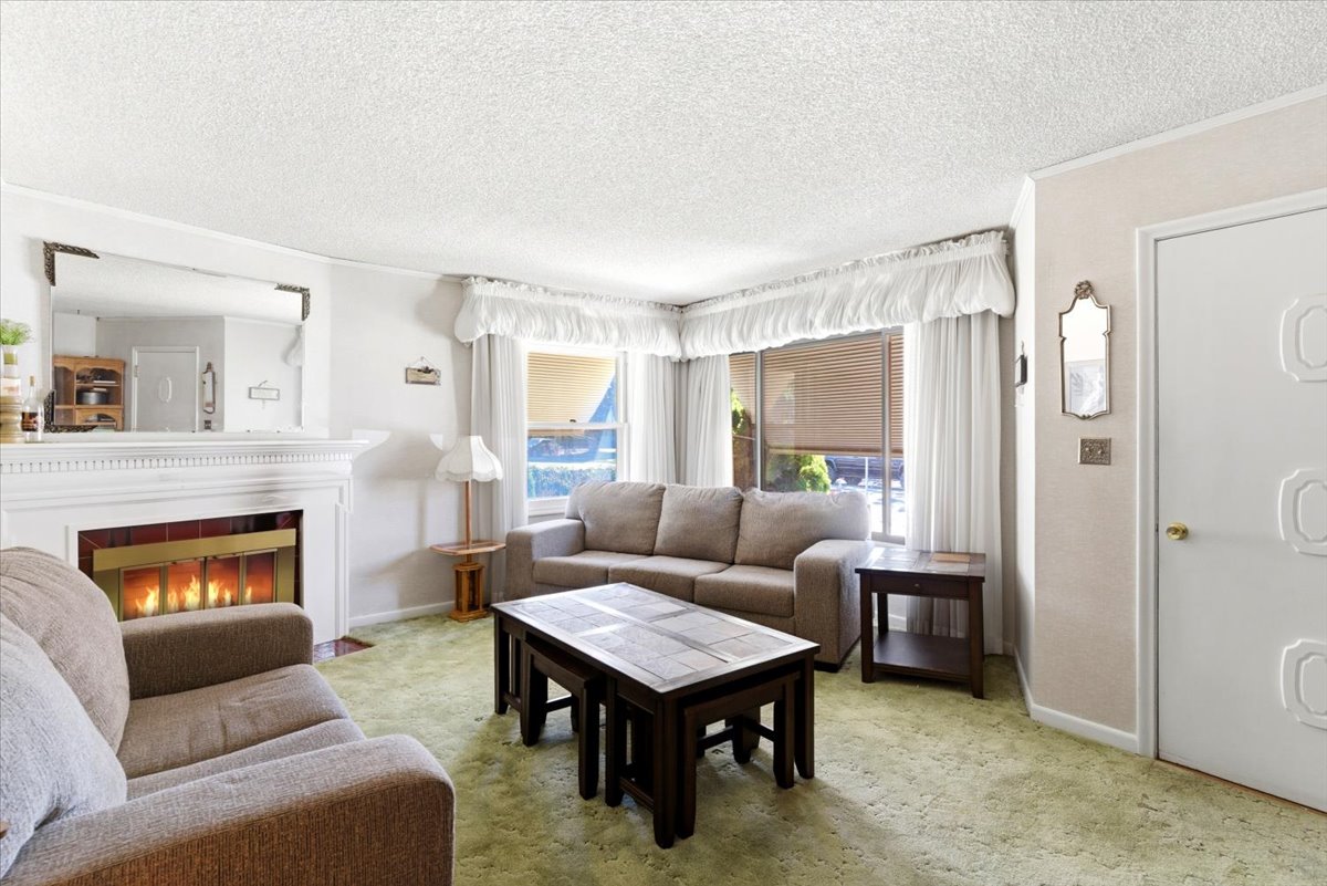 Living area with a fireplace featuring a white mantel and surround